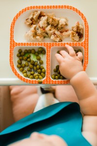 baby grabbing food from a plate
