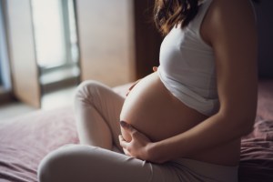 una embarazada sentada tocandose la barriga